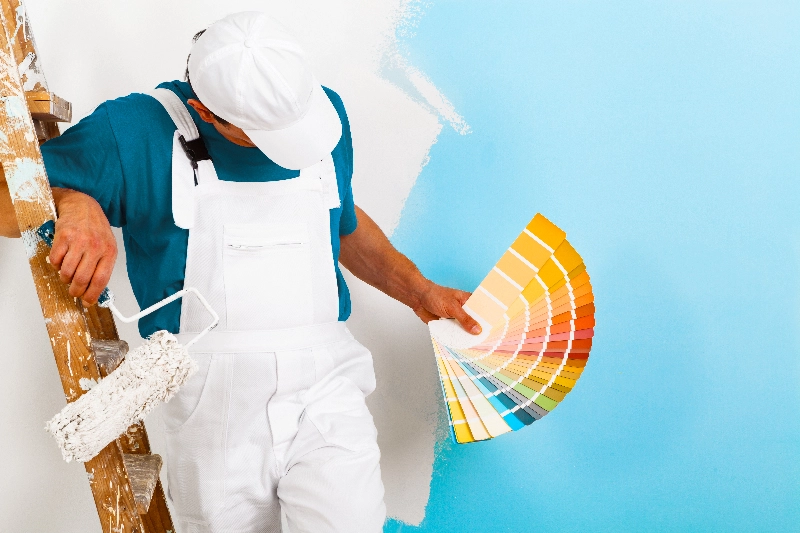 malarz wybiera kolory farb do ściany